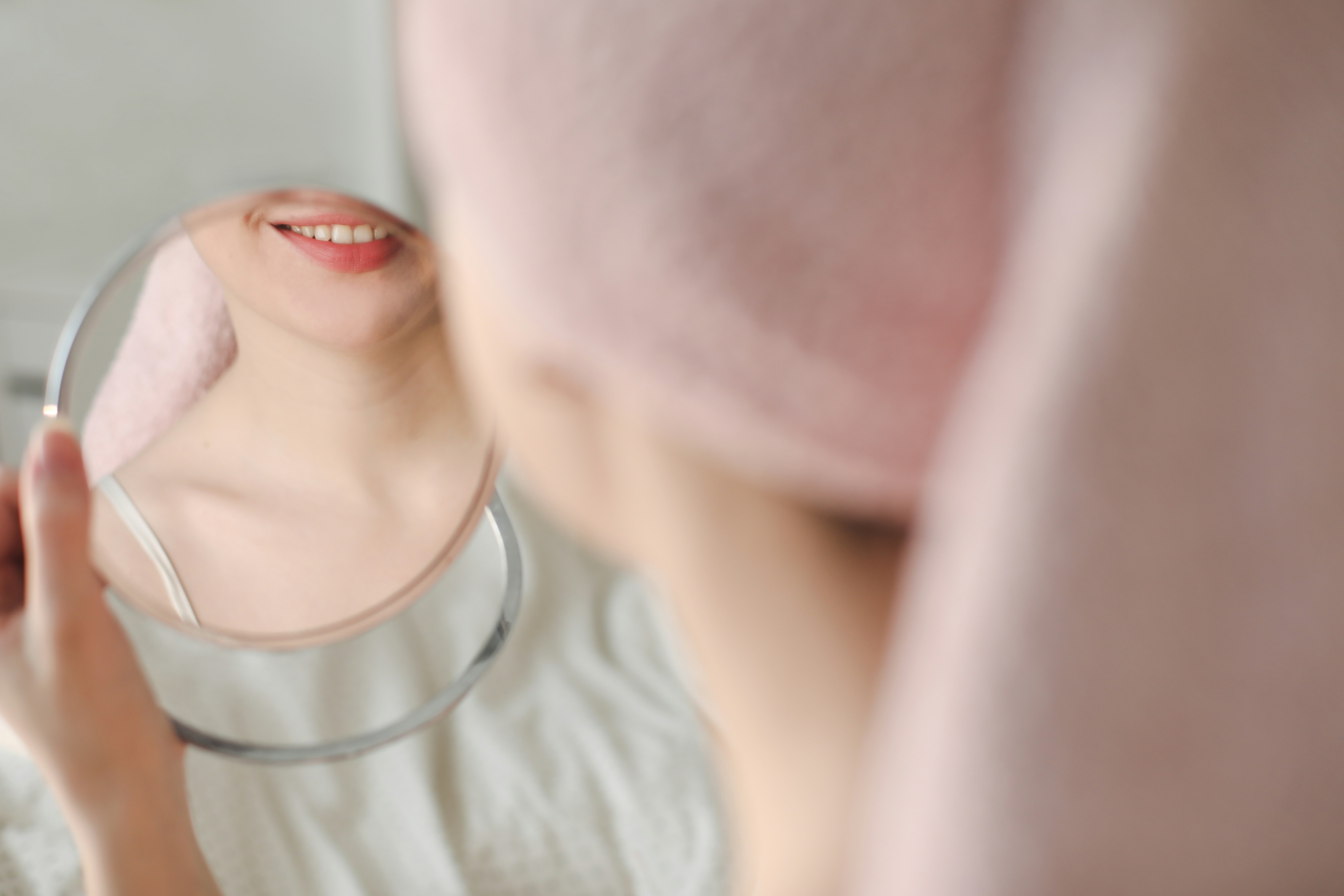 Woman smiling in front of mirror.