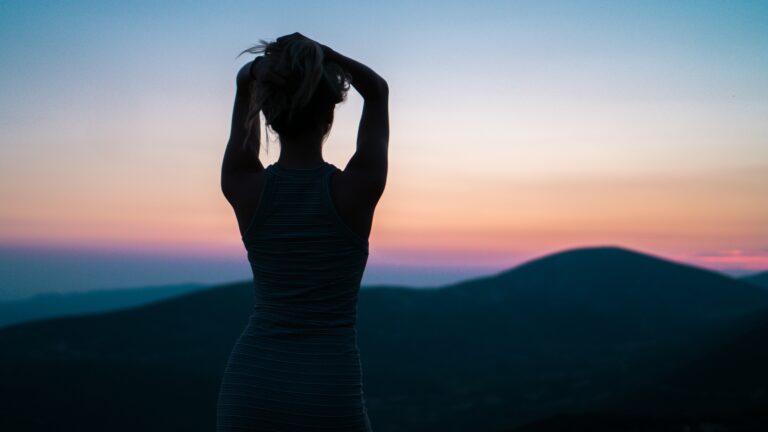 Woman staring at the mountains in the sunset
